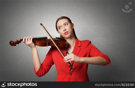 Pretty woman paly violin. Young pretty woman in red jacket playing violin