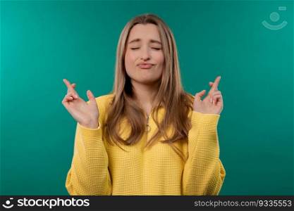 Pretty woman praying with crossed fingers on blue background. Lady begs someone satisfy her desires, help with, prays for her luck in exam. High quality. Pretty woman praying with crossed fingers on blue background. Satisfy desires