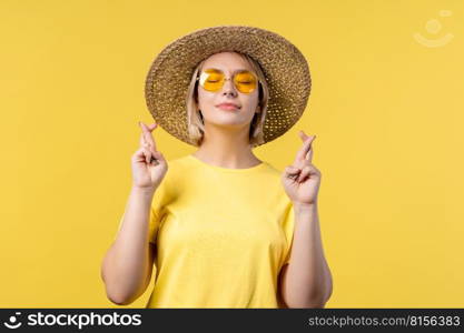 Pretty woman praying with crossed fingers on yellow background. Teenager girl begs someone satisfy her desires, help with, prays for her luck in exam. High quality photo. Pretty woman praying with crossed fingers on yellow background. Lady begs someone satisfy her desires, help with, prays for her luck in exam