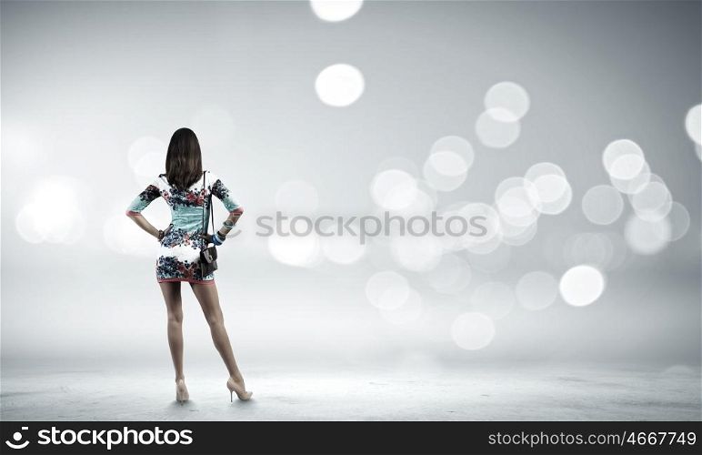 Pretty woman. Rear view of young attractive woman against bokeh background