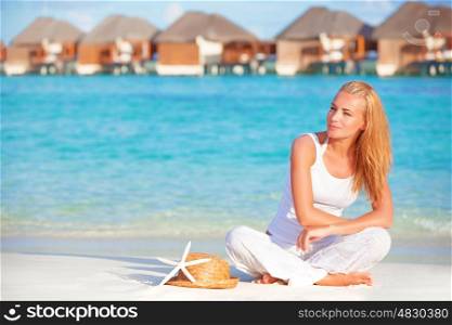 Pretty woman relaxation on the beach on tropical resort, luxury hotel on Maldives island, summer travel and vacation concept
