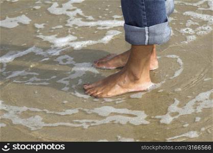Pretty woman standing barefoot in the sea