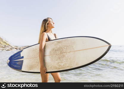 pretty woman swimsuit walking with surfboard sea
