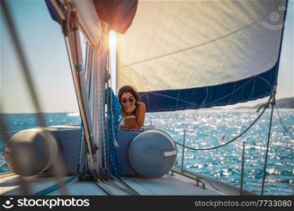 Pretty Woman Tanning on the Sailboat. Luxury Summer Trip to Greece. Recreation on Water Transport. Enjoying Vacation on the Yacht.. Pretty Woman on Sailboat