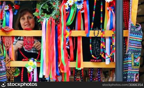 pretty woman tries Ukrainian folk ornaments on market