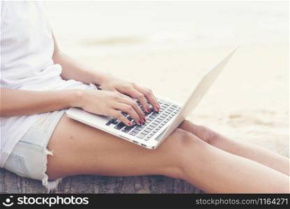 Pretty woman using laptop on the beach. Travel Concept