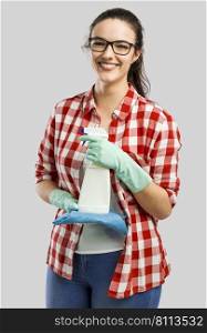 Pretty woman wearing gloves and holding a cleaning spray and a cloth