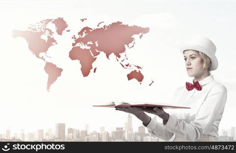 Pretty woman with opened book. Young woman in white cylinder and red bowtie with book in hands