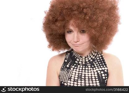 Pretty woman with red afro wig pulling a pouting face