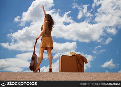 Pretty woman with suitcase and guitar