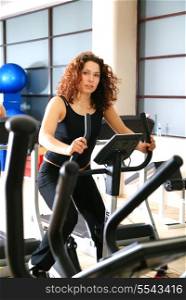 pretty woman working out at spinning byke at fitness gym