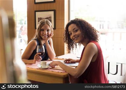 Pretty women talking and having fun inside coffee shop