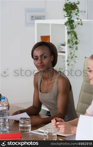 Pretty young african businesswoman working at her office in business environment