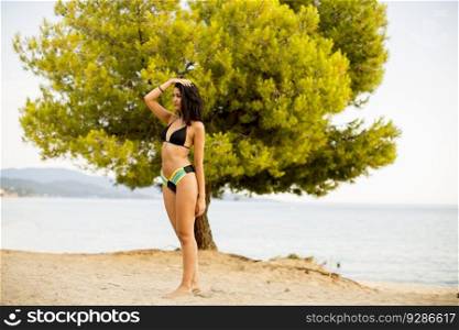 Pretty young and sporty girl posing on a beach at summer