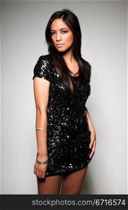 Pretty young Asian woman in a sequined black dress