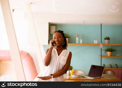 Pretty young black woman using mobile phone in the cafe