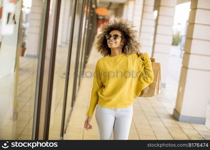 Pretty young black woman with curly hair in shopping