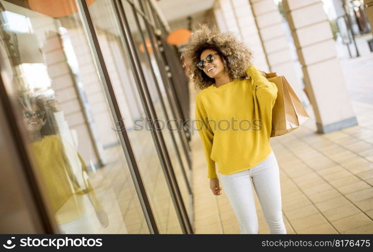 Pretty young black woman with curly hair in shopping