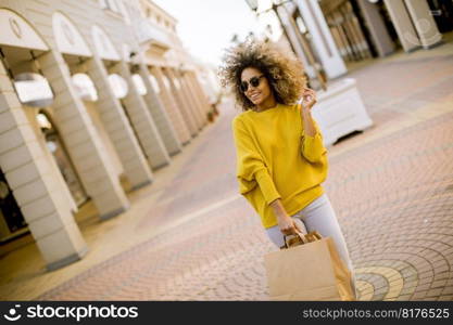 Pretty young black woman with curly hair in shopping