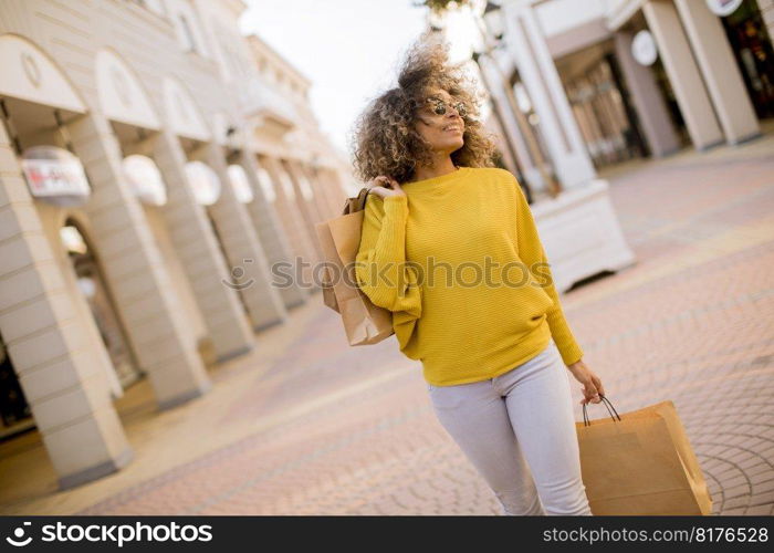 Pretty young black woman with curly hair in shopping