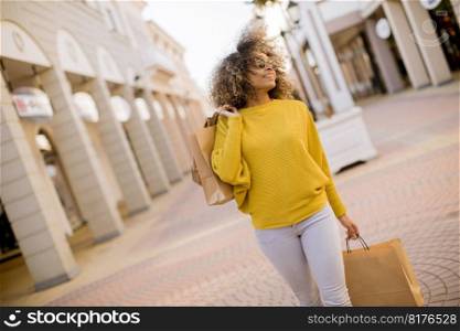 Pretty young black woman with curly hair in shopping