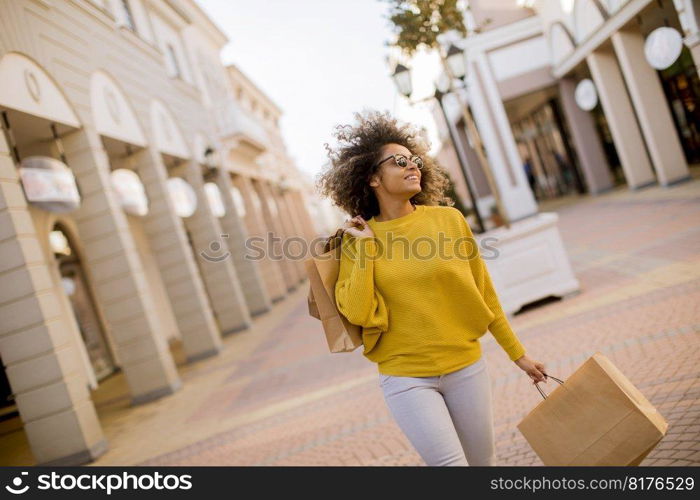 Pretty young black woman with curly hair in shopping