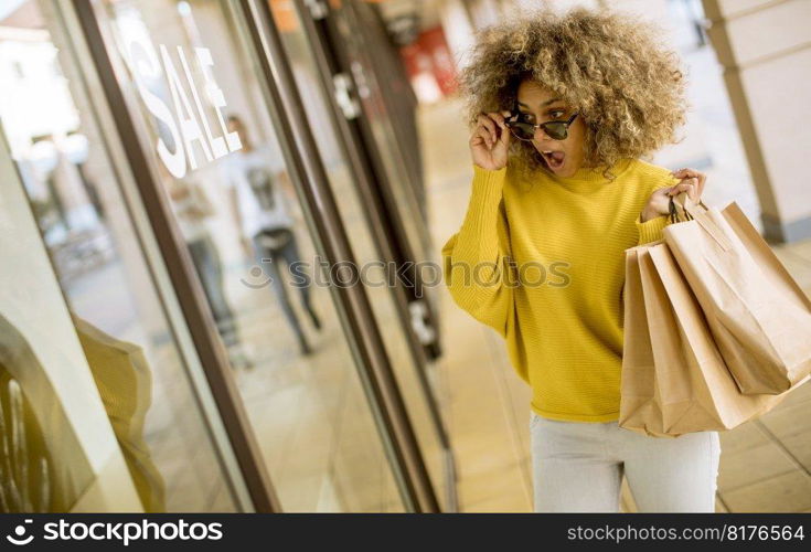 Pretty young black woman with curly hair in shopping