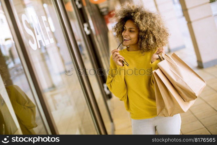 Pretty young black woman with curly hair in shopping