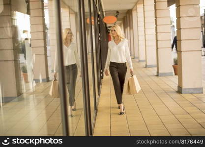 Pretty young blond woman in shopping on a street