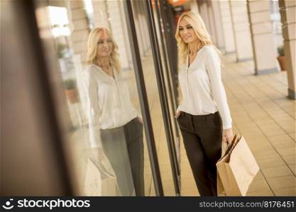 Pretty young blond woman in shopping on a street