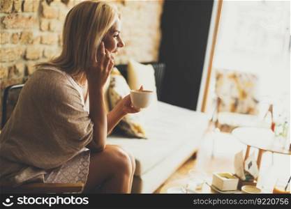 Pretty young blond woman sitting in the cafe