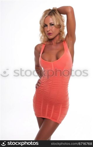 Pretty young blonde woman in a coral pink dress