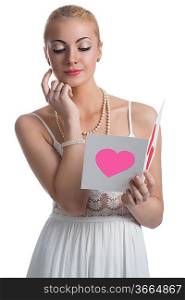 pretty young blonde woman with white dress thinking and reading valentine postcard on white background