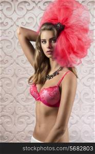 pretty young brunette girl with long hair wearing bra and big tulle accessory on the head, sexy pose, perfect body