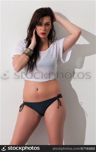 Pretty young brunette in a gray bikini and white top