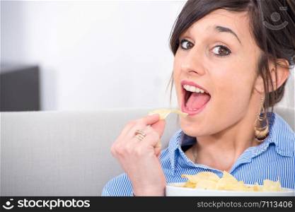 pretty young brunette woman eating chips