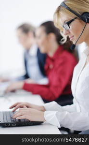 Pretty young business woman group with headphones smiling at you against white background