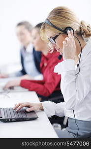 Pretty young business woman group with headphones smiling at you against white background