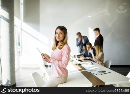 Pretty young business woman using digital tablet in the office