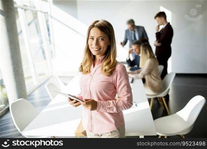 Pretty young business woman using digital tablet in the office