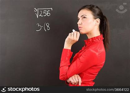 pretty young college student in act to think near a blackboard