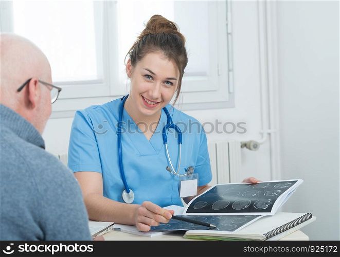 pretty young female doctor in the office with her patient