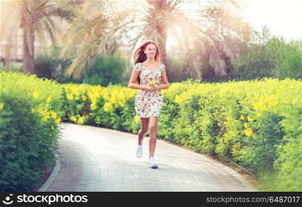 Pretty young female running in the park on sunny spring day, workout outdoors, happy healthy lifestyle of young people, activity and life energy concept. Pretty woman running in the park