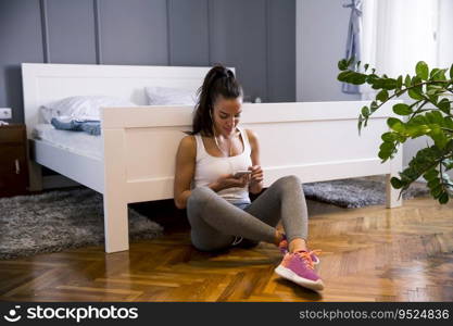 Pretty young fit woman choosing rightμsing for the exercises at home