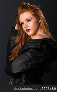 Pretty young freckled redhead in a leather jacket