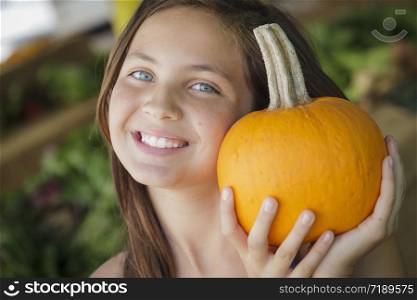 Pretty Young Girl Having Fun with the Pumpkins at the Market.