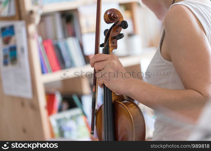 Pretty young girl practices on her violin, acoustic music