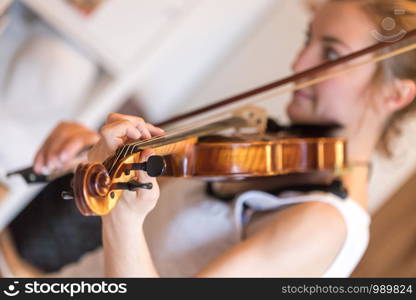 Pretty young girl practices on her violin, acoustic music