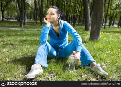 Pretty young girl runner in the forest with bottle of water