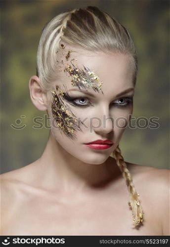 pretty young girl with blonde bride hair-style and naked shoulders posing with creative strong make-up on her perfect visage